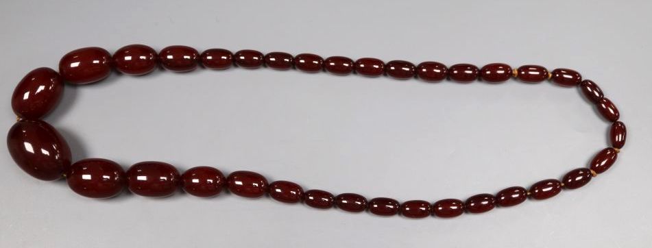 A single strand graduated simulated oval amber bead necklace, 52cm, gross 52 grams.